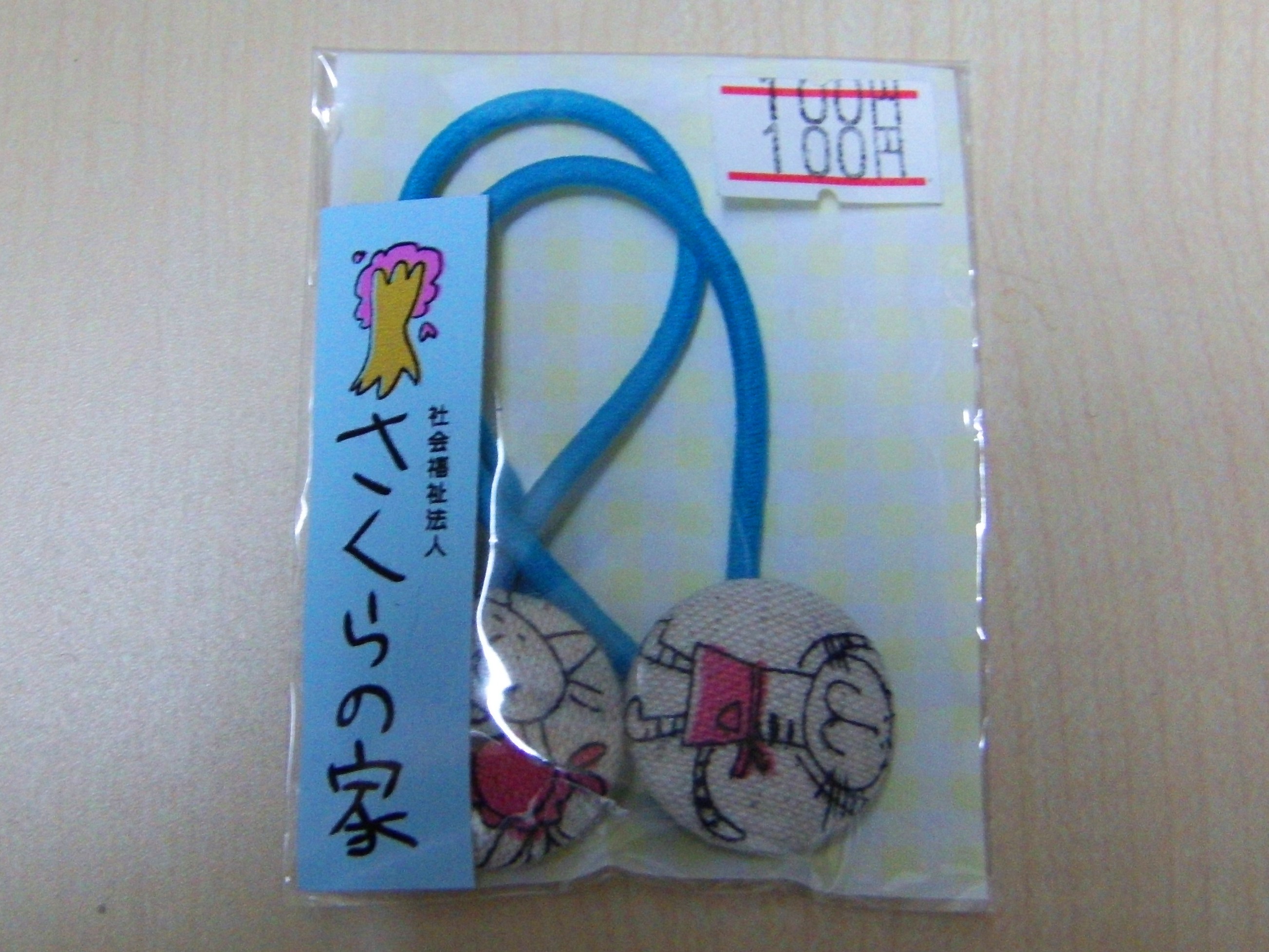 イラスト入りのボタンがついたゴムの画像